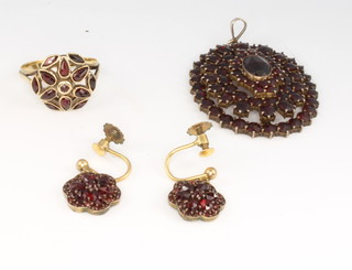 A yellow gold garnet ring, a pair of gilt earrings and a pendant 