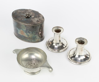 An oval silver plated tea caddy, a pair of candlesticks and a quaich 
