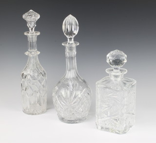 A square spirit decanter 23cm, a mallet shaped do. 34cm and a spirit decanter with cut decoration 34cm 