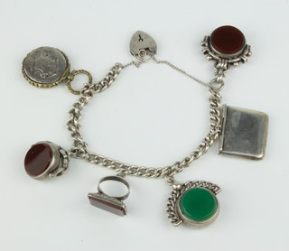 A silver charm bracelet with 4 hardstone seals, a stamp envelope and locket 