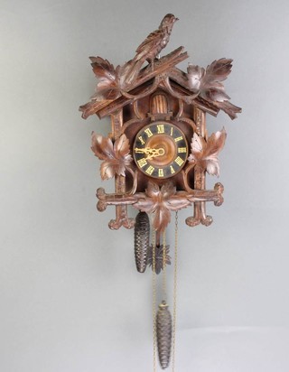 A Black Forest cuckoo clock, striking on a gong contained in a carved wooden case 30cm h x 31cm w x 16cm d