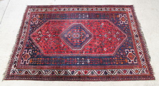 A Persian Qashqai red and blue ground rug with central medallion 293cm x 208cm 