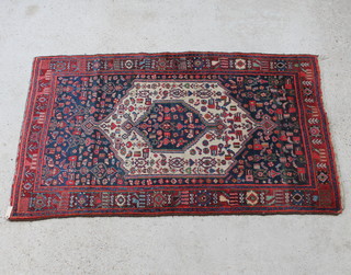 A blue and red ground Persian rug with diamond shaped medallion to the centre 217cm x 130cm 