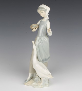 A Lladro figure of a girl with goose and bowl of food 25cm 