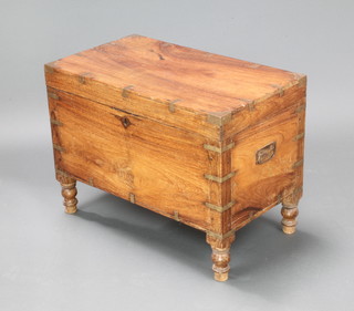 An Anglo Indian hardwood and brass banded trunk with hinged lid, fitted a candle box and with iron drop handles, raised on turned supports 46cm h x 62cm w x 35cm d 