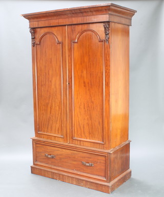 A Victorian mahogany wardrobe with moulded cornice the upper section with cupboard enclosed by a pair of arched panelled doors, the base fitted 1 long drawer 210cm h x 130cm w x 65cm d 
