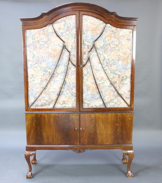 A 1930's Queen Anne style arch shaped mahogany display cabinet, fitted shelves enclosed by astragal glazed panelled doors, the base enclosed by panelled doors, raised on cabriole ball and claw supports 195cm h x 123cm w x 38cm d 