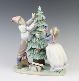 A Lladro group of a boy and a girl decorating a Christmas tree 5897, 29cm  