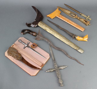 A Kris with a 32cm blade contained in an embossed metal and wooden scabbard (blade corroded), 1 other Kris with 22cm blade contained in a wooden scabbard, an Art Nouveau pierced gilt metal paper knife the handle decorated a classical lady 28cm, a wooden paper knife and 3 metal paper knives 