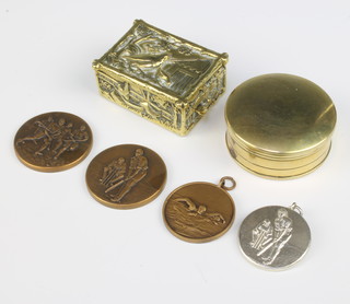 An 18th Century circular brass tobacco box with armorial decoration 2cm x 5cm heavily polished, a rectangular brass match box decorated birds 2cm x 5cm x 4cm together with 4 military sports medallions 