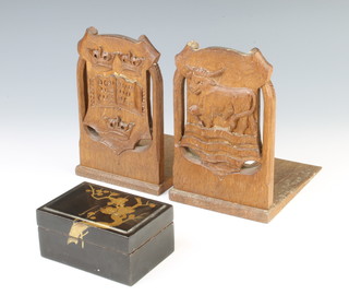 A Japanese rectangular black lacquered box the lid with floral decoration 4.5cm x 8cm x 7cm and a pair of oak bookends carved the Arms of Oxford University and The City of Oxford the bases marke Rogers 51 High Street Oxford  