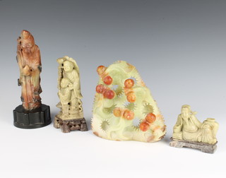 Four soapstone figures - a sage 17cm,  man and boy 15cm, reclining figure of a boy 7cm and a sculpture of fruits 8cm x 15cm x 18cm 

