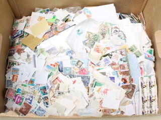 A collection of loose used world stamps in a brown box 