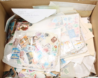 A collection of loose used GB and world stamps in a white box  