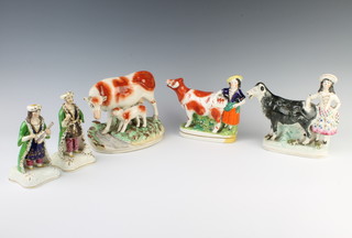 A pair of Staffordshire figures of a lady and gentleman, 2 cow creamers and a figure of a cow and calf 