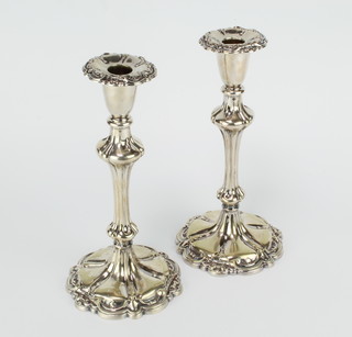 A pair of silver plated candlesticks with waisted stems 25cm 