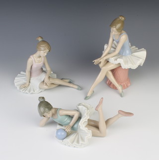 A Nao figure of a ballerina sitting on a pouffe 22cm, a seated do. 15cm and a reclining do. 22cm 