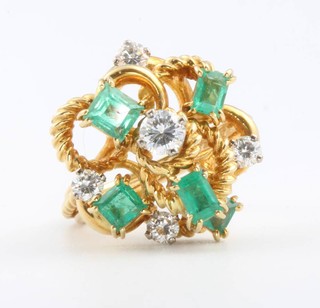 An 18ct yellow gold diamond and emerald ring, the 5 brilliant cut diamonds surrounded by baguette and princess cut emeralds size M 1/2