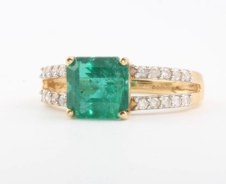 An 18ct yellow gold emerald and diamond open shank ring size N 