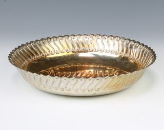 A circular silver dish with fancy S scroll handle, London 1960, 22 cm, with presentation inscription 395 grams 