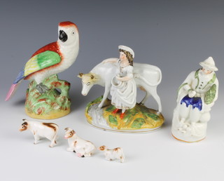 A Victorian Staffordshire figure of a parrot 19cm, a do. figure of a seated gentleman 17cm, a milkmaid and cow 16cm and 3 similar figures of cows 