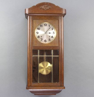 A 1930's striking wall clock with silvered dial and Arabic numerals contained in an oak case 