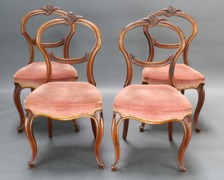 A set of 4 Victorian carved mahogany balloon back dining chairs with carved cresting rails, shaped mid rail and upholstered seat raised on French cabriole supports 