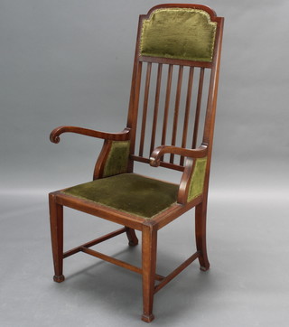 An Edwardian Art Nouveau mahogany stick and rail back open armchair raised on square tapered supports ending spade feet with H framed stretcher