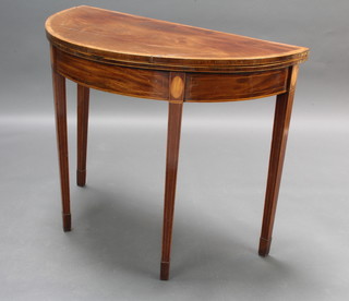 A Georgian inlaid mahogany demi-lune tea table with crossbanded top and inlay throughout, raised on square tapered supports ending in spade feet 73cm h x 91cm w x 45cm d 