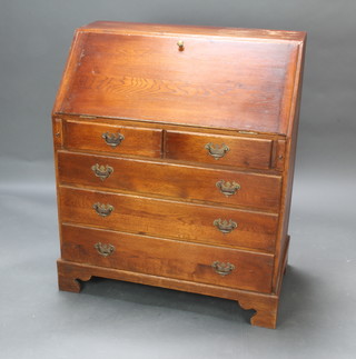 A Georgian style oak bureau, the fall front revealing a well fitted interior with pigeon holes, secret compartment above 2 short and 3 long graduated drawers, raised on bracket feet 104cm h x 87cm w x 48cm d 
 
