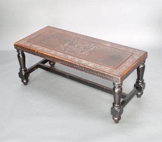 A rectangular ebonised and embossed leather coffee table, the top decorated an Inca god and raised on turned and block supports with H framed stretcher 41cm h x 100cm w x 45cm d 