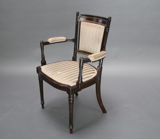 A 19th Century French ebonised open arm chair with upholstered seat and back raised on turned and fluted supports 