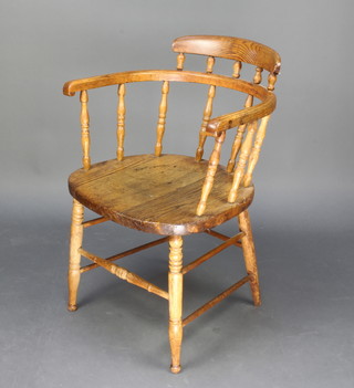 An elm hoop back chair with spindle turned decoration, solid seat, raised on turned supports with box stretcher 