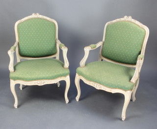 A pair of 19th Century grey painted French open arm salon chairs upholstered in green material, raised on cabriole supports 