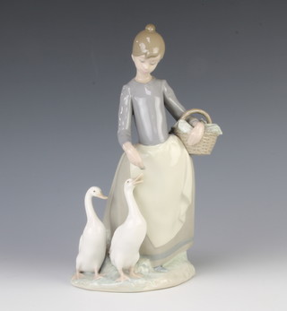 A Lladro figure of a girl feeding geese from a basket 1306 23cm 