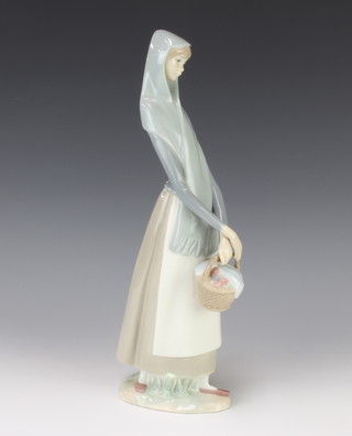 A Lladro figure of a lady holding a basket 32cm 