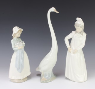 A Nao figure of a goose 33cm, a do. of a girl in a night dress 29cm and 1 of a girl holding a puppy 26cm 