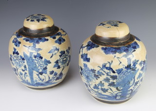 A pair of Chinese blue and white crackle glazed ginger jars and covers with prunus decoration 25cm 