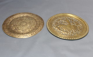 A circular "Persian" embossed charger decorated a mounted huntsman and animals 61cm diam. and 1 other embossed brass charger decorated figures and animals 61cm diam.  