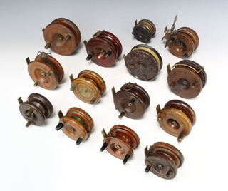 Five brass and wooden star back centre pin fishing reels and 9 other wooden centre pin fishing reels