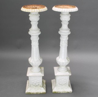 A pair of Victorian white painted cast iron pricket candlesticks with circular sconces, the body of bulbous reeded form and raised on a square base 103cm h x 28cm diam. 
