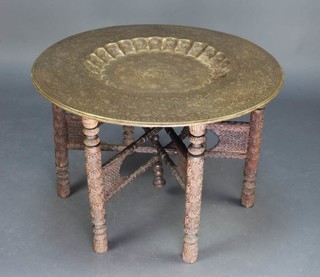 An Indian folding table, raised on 6 carved and turned supports with brass tray top 50cm h x 77cm  