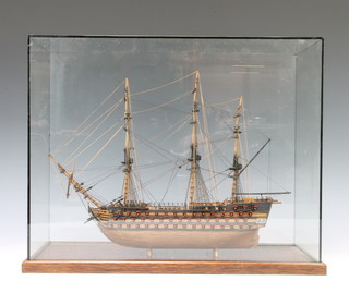 A 19th/20th Century wooden model of a 3  masted war ship contained in a glazed case 38cm x 46cm x 18cm 