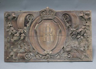 A Victorian carved oak plaque the centre with IR cypher and surrounded by carved garlands with grapes and pineapples 64cm x 101cm 