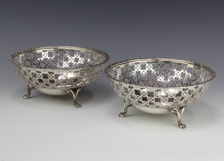 A pair of Edwardian silver bowls with pierced geometric decoration on paw feet, London 1909, 19cm, 740 grams 