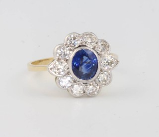 An 18ct yellow gold sapphire and diamond cluster ring, the centre stone 0.8ct surrounded by 10 brilliant cut diamonds 1.1ct, size O 