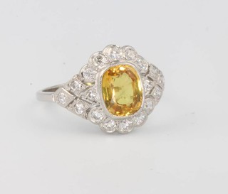 A platinum yellow sapphire and diamond cluster ring, the centre stone 2.0ct surrounded by brilliant cut diamonds 0.65ct size N 1/2