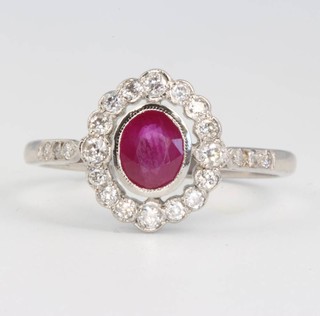 A platinum oval ruby and diamond cluster ring, the oval centre stone approx 0.75ct surrounded by diamonds 0.3ct size P 1/2 