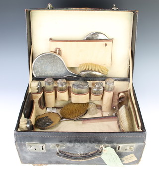 A toilet case containing 5 silver mounted bottles, 2 clothes brushes, a hand mirror, 2 hair brushes, London 1922 and 6 other mounted items 