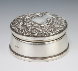 A circular silver trinket box the repousse lid with flowers and scrolls Birmingham 1995, 9cm diam. 